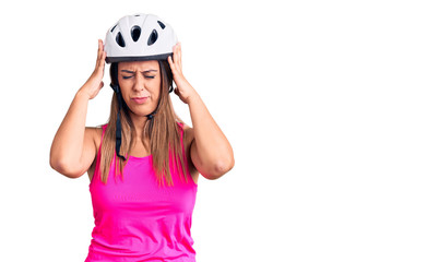 Young beautiful woman wearing bike helmet suffering from headache desperate and stressed because pain and migraine. hands on head.