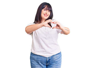 Young plus size woman wearing casual clothes smiling in love doing heart symbol shape with hands. romantic concept.