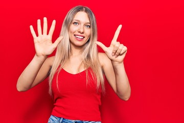 Young blonde woman wearing casual clothes showing and pointing up with fingers number seven while...
