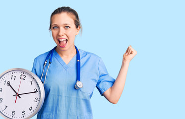 Young beautiful blonde woman wearing doctor uniform and stethoscope screaming proud, celebrating...