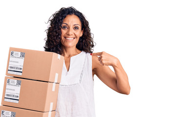 Middle age beautiful woman holding delivery package pointing finger to one self smiling happy and proud