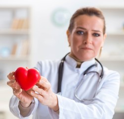 Cardiologist with red heart in medical concept