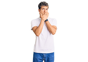 Young handsome man wearing casual white tshirt shocked covering mouth with hands for mistake. secret concept.