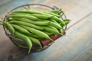 Raw green beans in metal basket