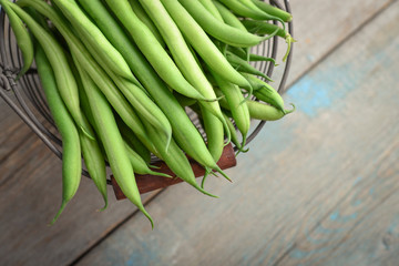 Raw green beans in metal basket