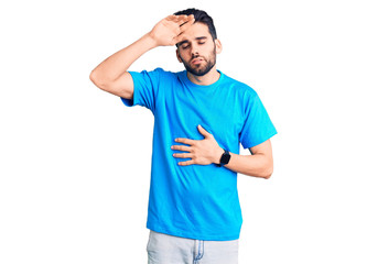 Fototapeta premium Young handsome man with beard wearing casual t-shirt touching forehead for illness and fever, flu and cold, virus sick