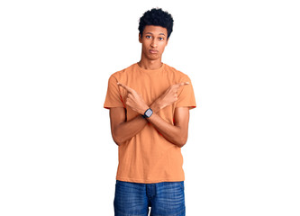 Young african american man wearing casual clothes pointing to both sides with fingers, different direction disagree