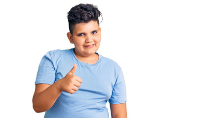 Little boy kid wearing sports workout clothes doing happy thumbs up gesture with hand. approving expression looking at the camera showing success.