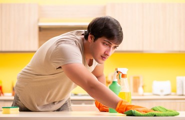 Obraz na płótnie Canvas Single man cleaning kitchen at home