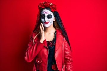 Woman wearing day of the dead costume over red touching mouth with hand with painful expression because of toothache or dental illness on teeth. dentist