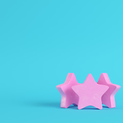 Pink three abstract stares on bright blue background in pastel colors