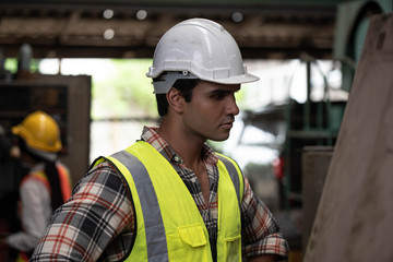 Portrait of Asian technician  handsome man or industrial worker with hardhat or helmet, eye protection glasses and vest working electronic machinery  mechanical  in Factory of manufacturing place