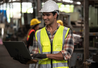 Portrait of Asian technician  handsome man or industrial worker with hardhat or helmet, eye protection glasses and vest working electronic machinery  mechanical  in Factory of manufacturing place
