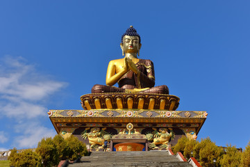 Fototapeta premium A selective focus image of Buddha statue at Buddha park with snow clad himalayan mountain range in the background as seen from Rabongla in Sikkim India