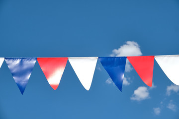 Red white and blue triangular bunting on sky background