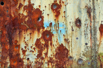 Old rusty metal background with bullet holes.