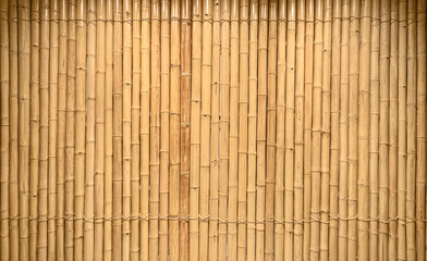 background and texture of decorative yellow bamboo wood on finishing wall surface.