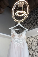 Luxury Lace Wedding Dress Hanging in room.