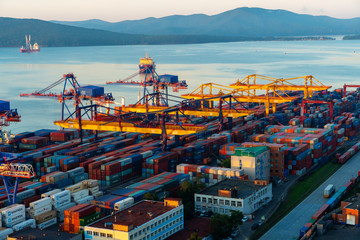Summer, 2020 - Vladivostok, Russia - Dawn in Vladivostok. Aerial view of the Vladivostok commercial sea port. Container terminal in Vladivostkoye against the background of the sea.