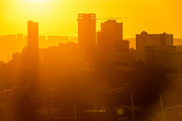 Vladivostok at dawn. Silhouettes of residential tall buildings against the backdrop of the rising sun.