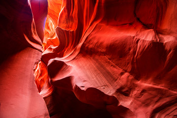 Red-orange sandstones stacked in layered fire waves in a narrow sandy labyrinth in Lower Antelope...