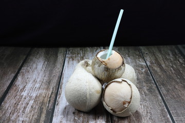 Pile of burned fresh coconut on the wooden table. Famous traditional tropical fruit in Asia. High vitamin and nutrition with freshness. 