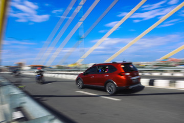 Fototapeta premium panning photo focus red or orange car on the road and bridge