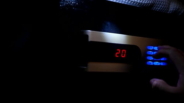Thief opens the digital safe. Stealing money and valuables at dark night.