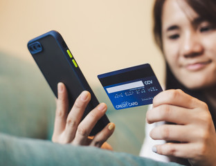 mobile business concept: Female hands holding credit card and smart phone for online shopping