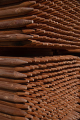 stacked peeled round pointed wooden fence posts