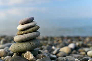 Pyramid of folded stones on top of each other naked on the sea, left.