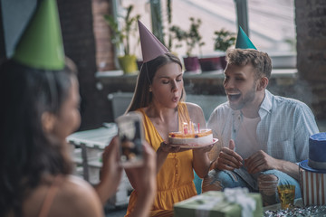 Woman blowing out candles on her birthday cake