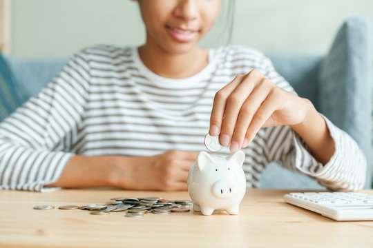 Success Asian girl is put coins in piggy bank For future scholarships 