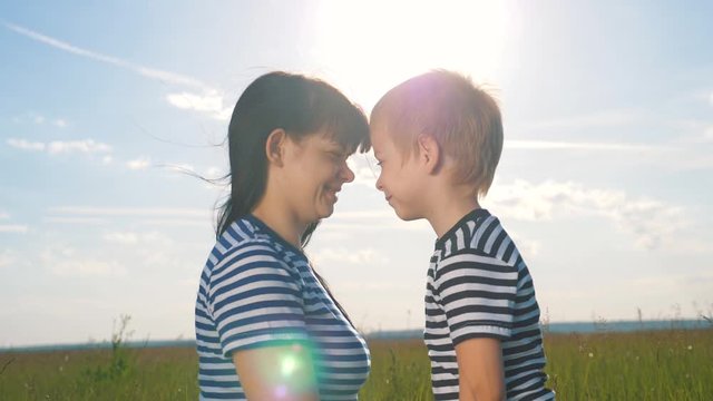 Happy family together. At sunset, the mother hugs her son, noses touch, enjoys socializing on a walk. The concept of travel and recreation.