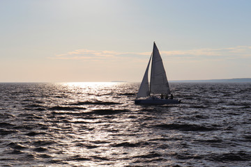 Obraz premium A sailing boat sails on the sea. Open sails. Active sport. Sailing on a yacht.