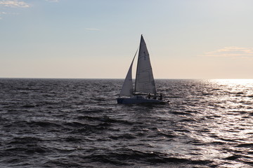 Fototapeta na wymiar A sailing boat sails on the sea. Open sails. Active sport. Sailing on a yacht.