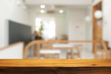 coffee shop blurred background with empty wooden desk montage.
