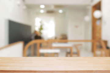 coffee shop blurred background with empty wooden desk montage.