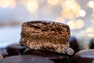 comida típica argentina alfajores de chocolate rellenos de dulce de leche de fondo luces de navidad 