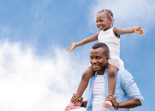 Happy father carrying daughter on shoulders, Cheerful african american girl on the shoulders of his father with clipping path
