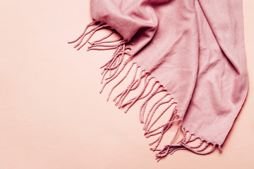 Pink cozy scarf with tassels on pastel background. Minimal winter or autumn background for your...