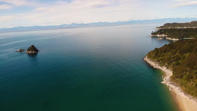 Abel Tasman aerial birds eye fly to horizon shot. Sandfly bay, Pinnacle Island, New Zealand.