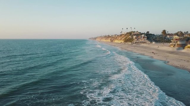 Amazing aerial view in 4k of the moonlight beach California coastline at a warm and sunny day with blue sky