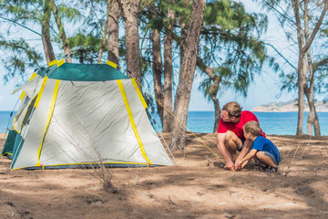 Camping people outdoor lifestyle tourists put up set up green grey campsite summer forest near...