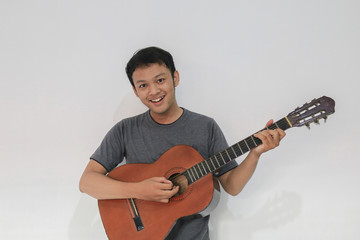 Obraz premium Happy and smile Young Asian man musician with guitar