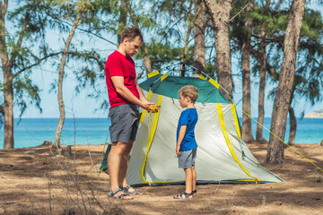 Camping people outdoor lifestyle tourists put up set up green grey campsite summer forest near...