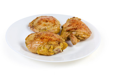 Crispy fried chicken thighs on the white dish close-up