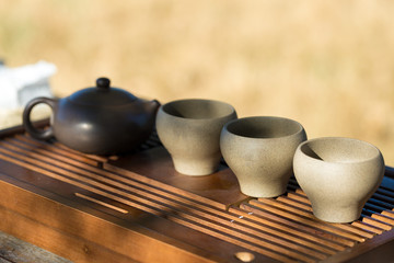 Chinese tea ceremony. Ceramic teapot made of clay and bowls on a wooden background.