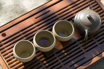 Chinese tea ceremony. Ceramic teapot made of clay and bowls on a wooden background.