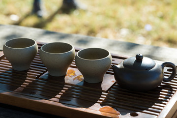 Chinese tea ceremony. Ceramic teapot made of clay and bowls on a wooden background.